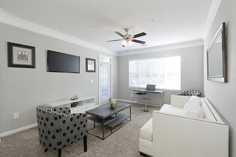 a living room with a ceiling fan and a couch